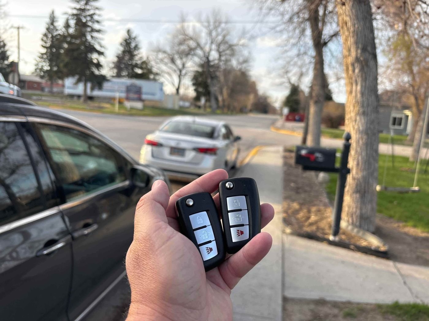 Two newly programmed keys held next to a vehicle in Wyoming